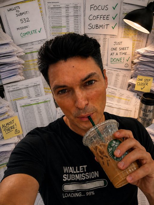 A man takes a selfie sipping an iced Starbucks coffee while wearing a "Wallet Submission Loading... 99%" shirt, surrounded by a wall covered in "Wallet Submissions" spreadsheets and motivational sticky notes like "Focus ✓ Coffee ✓ Submit ✓," "Just one sheet at a time...Done! ✓," and "Almost there!" The image captures the hectic last-minute scramble of finalizing wallet submissions before the OpenSea launch mentioned in the post, humorously framing his coffee break as "fuel ing the mission."