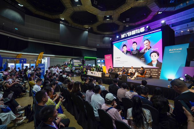 A panel discussion titled "MYB" with the subtitle "Activate Retail Stage" takes place on stage, featuring speakers shown on the large screen, including Benjamin Chuang (Luno), Ram Tan (Global Trade Finance Inc), and Alan Hung, as the audience watches from the "Activate Retail Stage" at what appears to be a crypto or fintech conference.