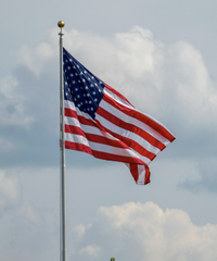 An American flag waves against a partly cloudy sky, symbolizing the United States as Ripple's CEO highlights the nation's unprecedented proximity to establishing clear cryptocurrency regulations.