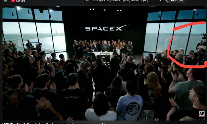 The image shows a large crowd of people gathered together for an event at a space museum or exhibition. The attendees are standing around, with some holding up their phones to take pictures. A red circle is visible in the top right corner of the screen, which appears to be a caption related to the event.