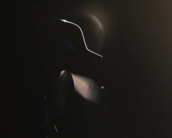 A dim close-up shows a person’s hands holding a dark VR headset or headset-like device with a bright illuminated edge.