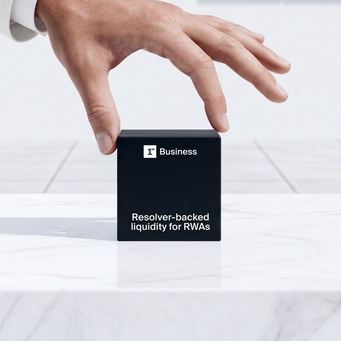 A promotional image showing a hand reaching down toward a black cube on a marble surface that reads '1° Business' and 'Resolver-backed liquidity for RWAs'.