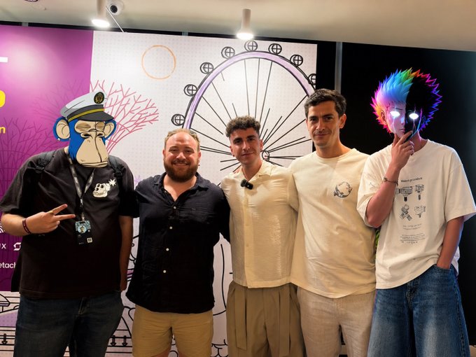 Five people pose together at the Solana Summit, with two wearing NFT profile pictures (one a Bored Ape Yacht Club-style monkey and the other a colorful neon-haired character) on digital displays covering their faces, standing in front of a branded backdrop featuring Solana's purple and pink logo.