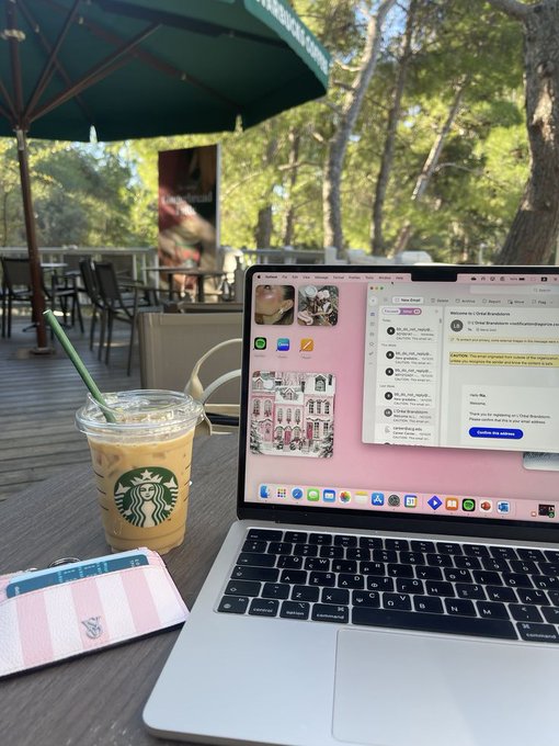 The image shows an iced Starbucks coffee and a MacBook displaying Messages with a contact "Brad Banerjee" and a conversation mentioning "Chill Bananas," set at an outdoor patio with a green umbrella. The caption "No mint, no shortcut" aligns with the post's theme of skepticism toward surface-level trading results, mirroring the understated, work-in-progress setup shown in the image rather than any flashy celebration of gains.