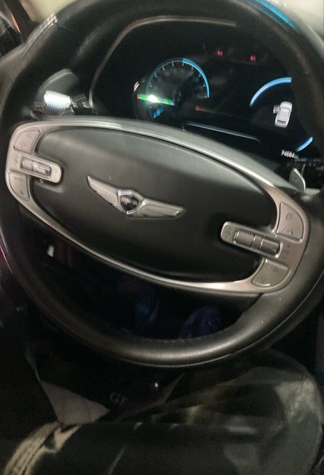 A nighttime view inside a Genesis vehicle showing the steering wheel emblem and illuminated digital dashboard, with an odometer reading of 74884 miles—suggesting the "Gn" in the post is likely a typo for "GM" or a nod to driving miles.