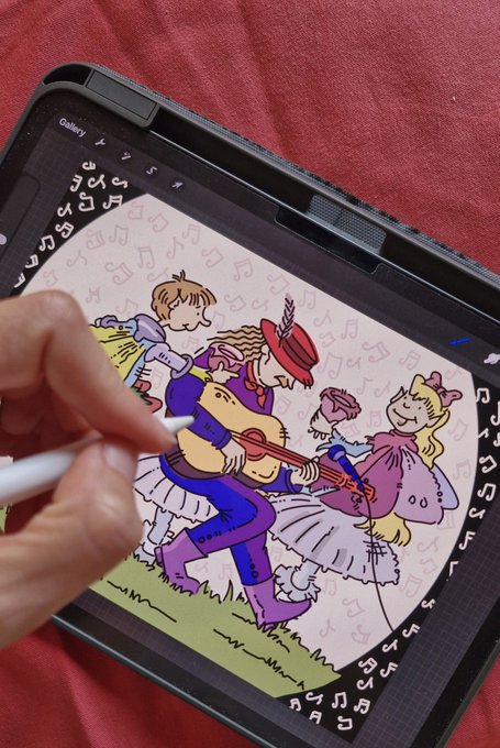 A person uses a white stylus to digitally illustrate a whimsical scene of children playing musical instruments on a tablet, with a pattern of music notes along the screen's border.