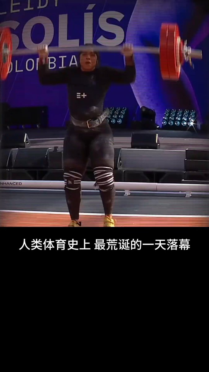 The image features a woman lifting weights, with her arms raised high above her head as she performs an exercise. The photo has been captioned in both English and Chinese, which suggests that this might be related to a weightlifting competition or event taking place in China.