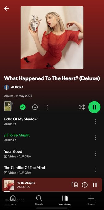 A Spotify mobile app screenshot showing the album 'What Happened To The Heart? (Deluxe)' by AURORA, released on 2 May 2025, with the track 'To Be Alright' currently playing and other songs like 'Echo Of My Shadow' visible in the tracklist.
