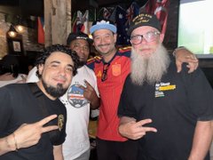 A group of friends smile and pose together at a social event, with one man in the center wearing a red "Cabo Verde" FIFA World Cup jersey and a blue "Bored Ape" cap, while another sports a long white beard and a Sports Monke NFT cap. The image captures the post's celebration of an IRL NFT community gathering at Berry Park, highlighting membership rewards and Cabo Verde World Cup pride.