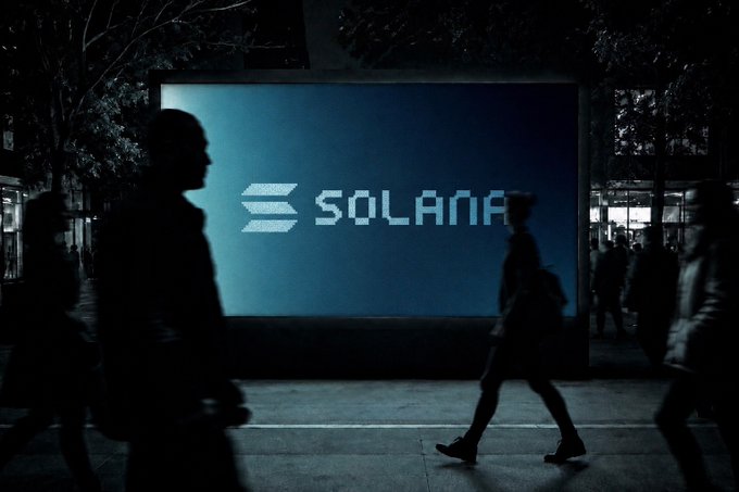 A nighttime urban scene showing silhouettes of pedestrians walking past a large illuminated billboard displaying the 'SOLANA' logo and branding.