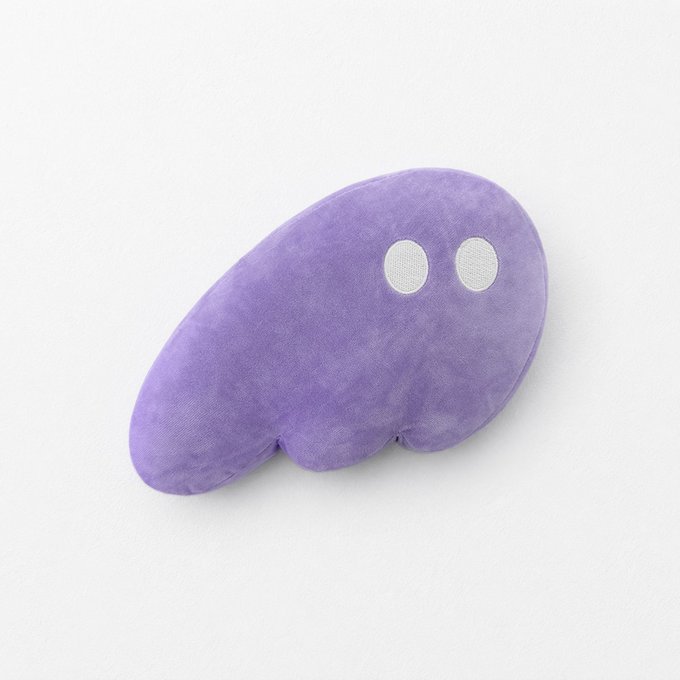 A purple, plush, blob-shaped character with two white eyes sitting on a plain white background.