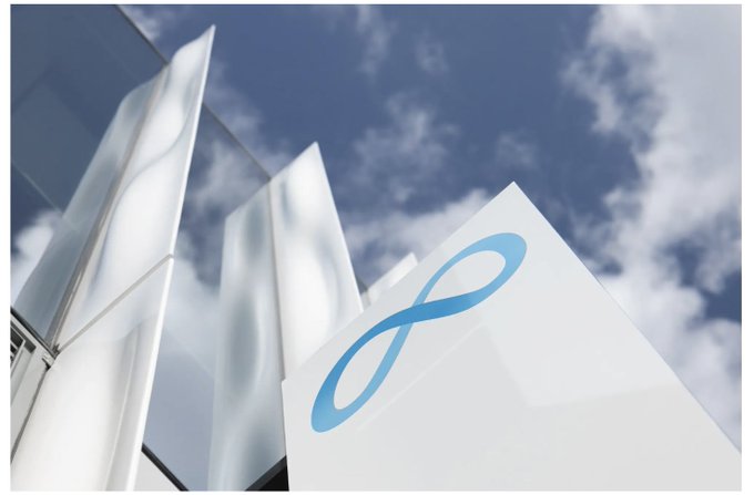 A low-angle shot captures a sleek, modern building with reflective glass panels and a blue infinity-style logo against a partly cloudy sky, visually symbolizing Meta's bold expansion into cloud computing to monetize its surplus AI infrastructure.