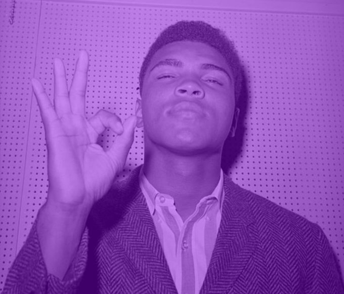 The image features a man wearing a black jacket with white and grey stripes, making him look like an action movie star or possibly a hipster. In his right hand, he is holding up his fingers as if giving the "ok" sign - a universal gesture for an action shot or an important statement. The surrounding background appears to be purple, which adds color to the scene and contrasts with the man's outfit. This combination of colors and symbols creates an overall vibe that suggests the photo might be related to an online post discussing the recent release of the movie "ARX MODE ACTIVATED."