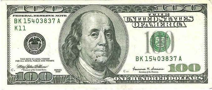 The back of a US one hundred dollar bill featuring Benjamin Franklin, with visible serial number 'BK 15403837 A' and markings 'K11'.