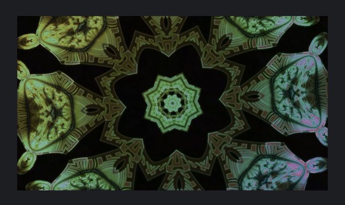 A vibrant green kaleidoscopic mandala pattern with symmetrical star-like shapes radiating from the center against a dark background.