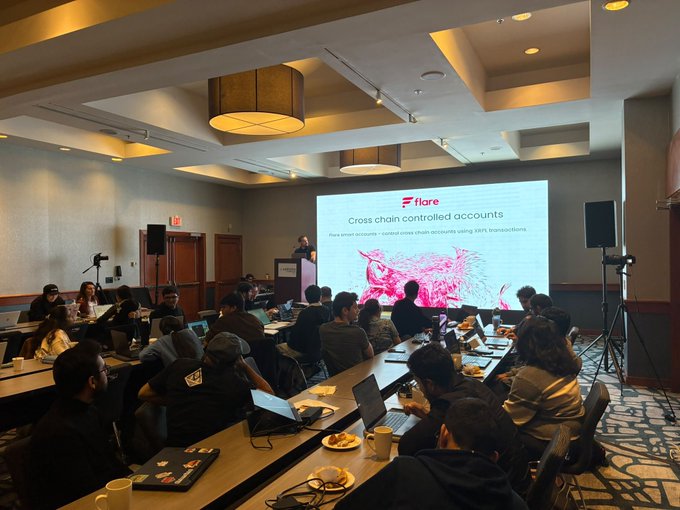An audience attends a presentation in a conference room where a slide displays the 'Flare' logo and text reading 'Cross chain controlled accounts'.