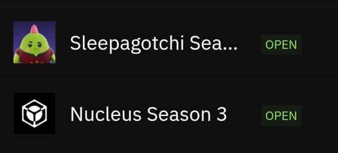 A dark interface shows two game options with 'OPEN' buttons: 'Sleepagotchi Sea...' featuring a green pear-like character with a pink bow, and 'Nucleus Season 3' with a cube icon.