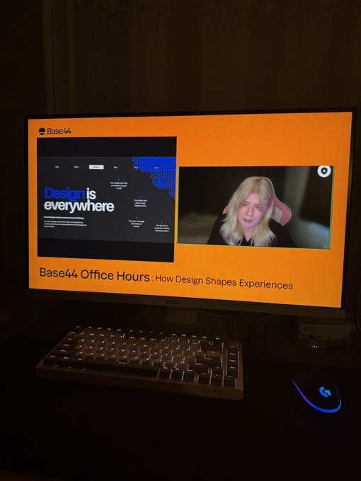 A computer monitor displays a Base44 Office Hours video call titled "How Design Shapes Experiences" with "Design is everywhere" text, alongside a mechanical keyboard and Logitech mouse.