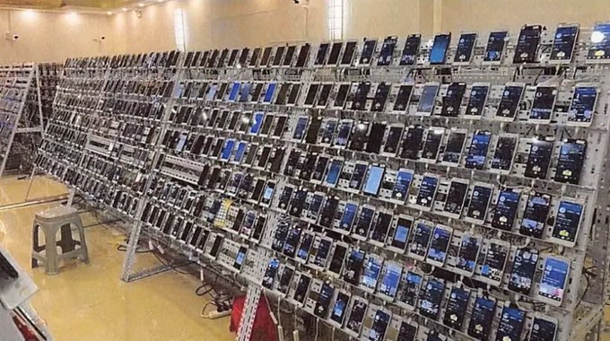 A large collection of cellphones is neatly arranged along several shelves in a room full of electronics, with some stacked high above other phones as well. The text on the image states that "The US government just seized $8 BILLION in Bitcoin from a single Cambodian businessman. The largest forfeiture in American history. Most people have never heard his name". There is also another image at the bottom which appears to be blurry or out of focus, but it does not seem relevant to the main topic of the image, which is the stolen Bitcoins and their location in a room full of electronics."