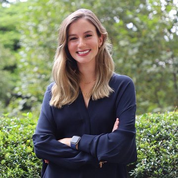 The image features a woman with blonde hair wearing a blue blouse, standing next to some bushes or hedges outside. She has her arms crossed over her chest and is smiling at the camera. The caption of the photo reads "JUST IN: Kalshi announces $HYPE Perpetuals are now live for trading." This suggests that there might be an ongoing promotion or event related to a particular brand, product, or service in the market.