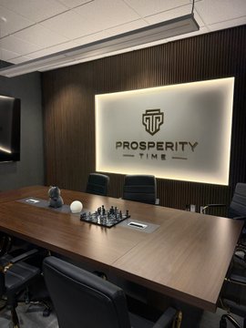 A sleek conference room at "Prosperity Time" features a long wooden table with a chess set, while the backlit wall displays the company's logo, tying into the post's confident caption about a top student's success and "billions loading."
