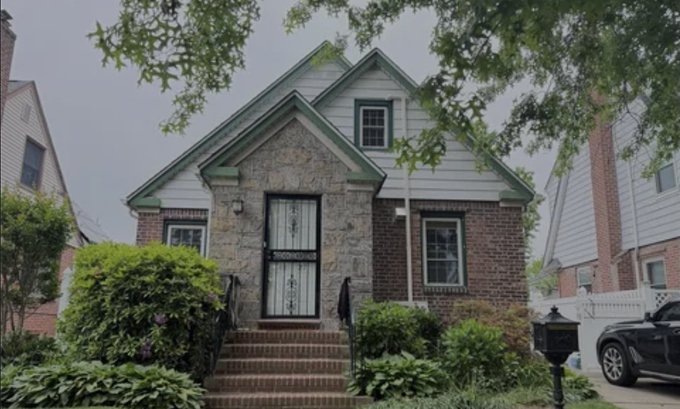 A modest brick and stone Cape Cod-style home with a small front yard stands in a quiet suburban neighborhood. The image contrasts the unassuming exterior of this typical house with the post's breakdown of its staggering $1.2 million price tag, illustrating that even modest-looking homes in the area carry costs requiring significant Bitcoin holdings.