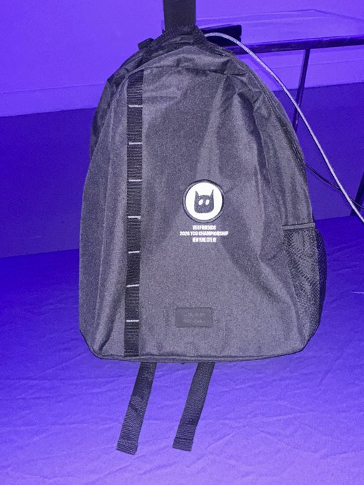 A black backpack with a circular white logo featuring a stylized cat/character face and text indicating 'WEB3 Hack 2024', photographed against a blue-lit background.