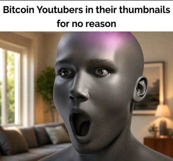 A shocked gray mannequin face is shown in a domestic setting with text above reading "Bitcoin Youtubers in their thumbnails for no reason," humorously mocking the exaggerated facial expressions and dramatic thumbnails commonly used by crypto influencers to lure viewers into paid groups and boost engagement.
