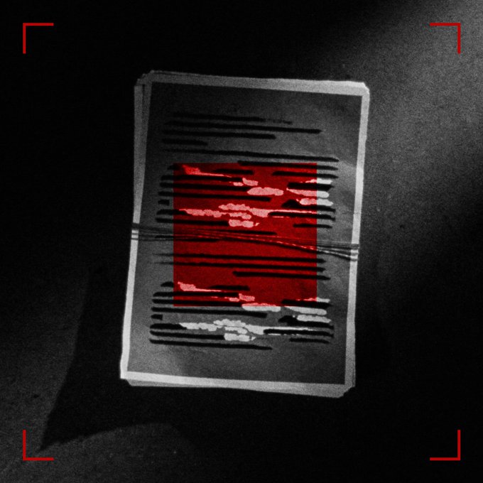 Dark, grungy image of a document with text redacted by black bars, with a prominent red square in the middle that has also been partially redacted, framed by red corner brackets.