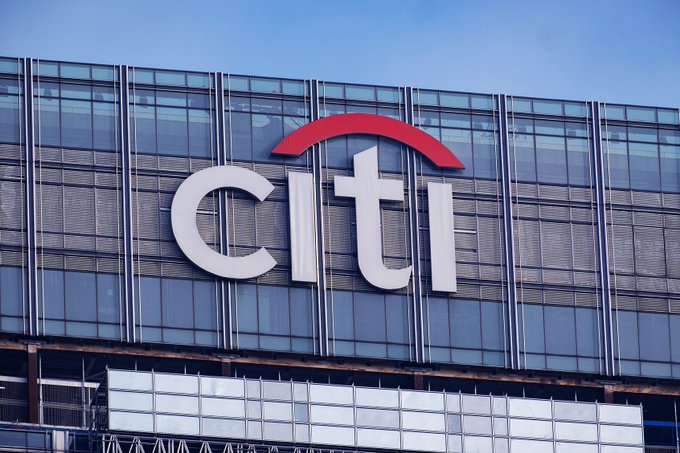 A large "citi" logo is displayed on the glass facade of a modern building, representing Citibank as it announces its $2.8 trillion move into crypto custody and tokenized deposits.