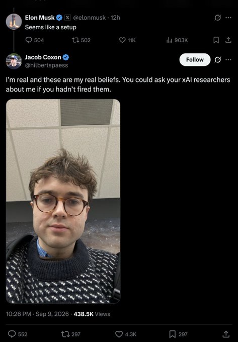A screenshot shows Elon Musk's tweet "Seems like a setup" with a quote-tweet from Jacob Coxon (@hilbertspassy) claiming "I'm real and these are my real beliefs. You could ask your xAI researchers about me if you hadn't fired them," accompanied by a selfie of Coxon. The post caption "Lmao" suggests amusement at the exchange, where Musk appears to be implying Coxon's response was a manufactured or staged defense.