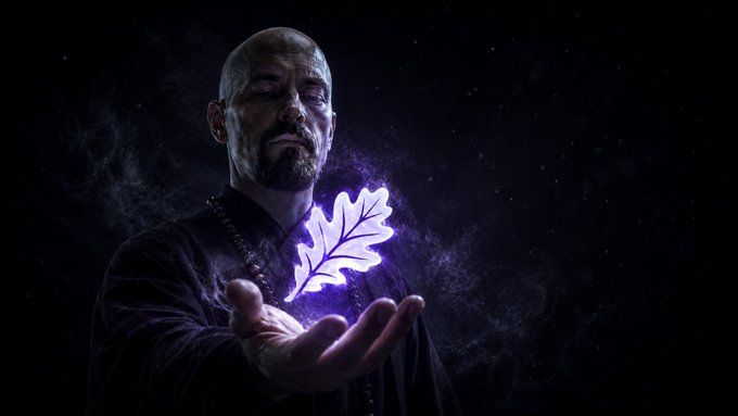 A bald, bearded man in dark robes holds a glowing purple leaf in his outstretched palm against a smoky black background, evoking a mystical or alchemist-like image. This magical imagery reinforces the post's promise of "magic" for crypto traders, suggesting BladTrade transforms idle assets into productive, yield-generating power just as the glowing leaf seemingly defies physics in his hand.