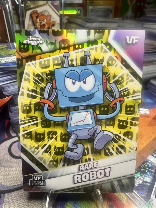 A shiny holographic trading card features a blue, square-headed cartoon character and is labeled "RARE ROBOT," "VF FIRST CHROME," and "Topps Chrome."