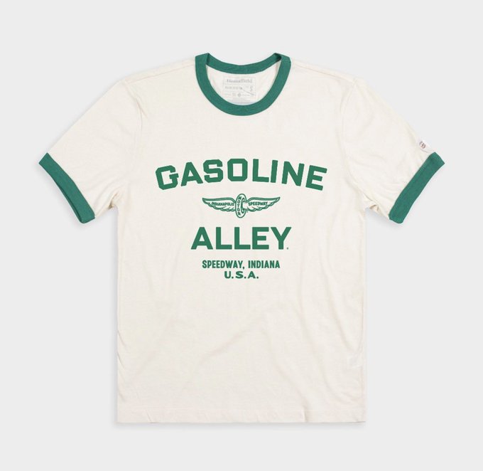 A cream-colored ringer t-shirt with green trim, featuring the text 'GASOLINE ALLEY' and 'SPEEDWAY, INDIANA U.S.A.' along with a winged automotive emblem in green.