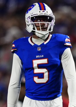A Buffalo Bills football player wearing a blue jersey with the number 5 and a white helmet stands on the field during a game.