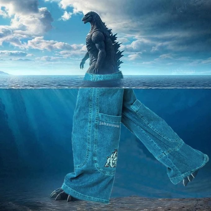 A surreal digital artwork showing Godzilla above the water wearing blue denim jeans, with the 'jahzuuuu' watermark visible.