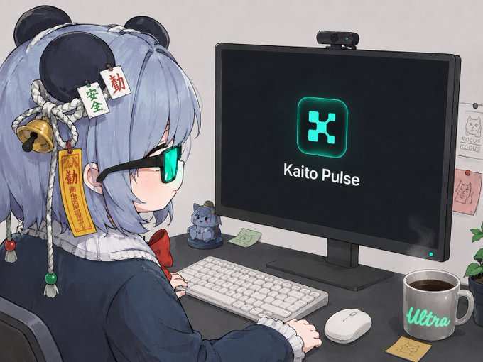 An anime-style illustration of a blue-haired girl with bear ear accessories looking at a computer monitor displaying 'Kaito Pulse' logo, with a small cat figurine and 'Ultra' branded coffee mug on the desk.