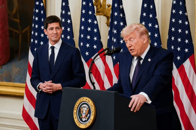Donald Trump and a man in a navy suit stand near American flags, with Trump speaking at a podium featuring the Presidential Seal, likely referencing economic policy which influenced Bitcoin's rise.