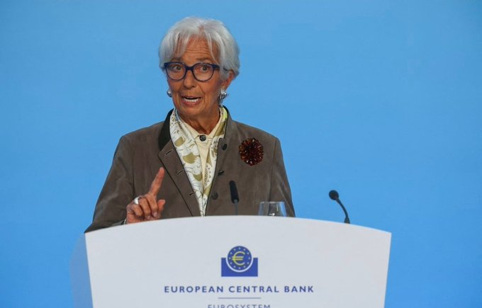 A photo of Christine Lagarde, President of the European Central Bank, speaking at a podium with the ECB Eurosystem logo visible at the bottom.