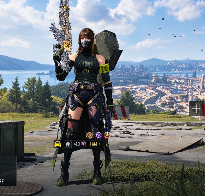 A video game character wearing a green tactical outfit and mask holds an ornate sword, standing in a ruined landscape with a city and water in the background; the UI shows '419', 'I AM', and several icons.