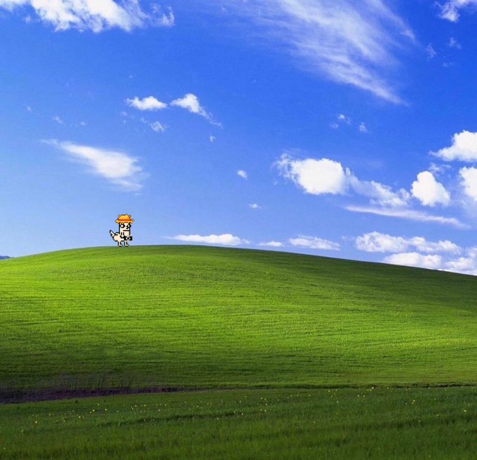 A pixel-art figure standing on a green grassy hill against a blue sky with scattered clouds.