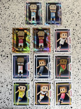 The image features a collection of ten miniature figurines, each representing a different soccer player from various teams. The players are depicted in a variety of poses, showcasing their unique styles and personalities. Some of them are standing upright while others are sitting or lying down on the ground. The figurines are arranged in two rows, with five figures in each row, creating an organized and visually appealing display.