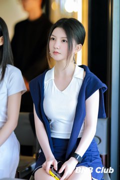 A young woman wearing a white top with a navy sweater draped over her shoulders sits holding a yellow item, with the text "BNB Club" visible in the corner. The image appears to promote a BNB Club tennis match celebrating Binance's 9th anniversary, fitting the post's commemorative theme.