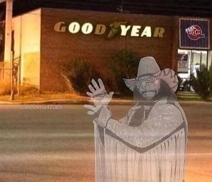 A grainy nighttime photo shows a Goodyear tire shop with a hand-drawn cowboy figure superimposed in the foreground; the watermark reads '@Johnmc42069'.