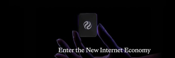 Hands holding a dark card with a swirling logo in a dark setting, with the text 'Enter the New Internet Economy' at the bottom.