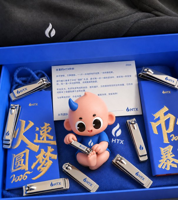 A promotional gift box from HTX features a small devil figurine, blue envelopes with gold Chinese characters, and a note dated 2026.