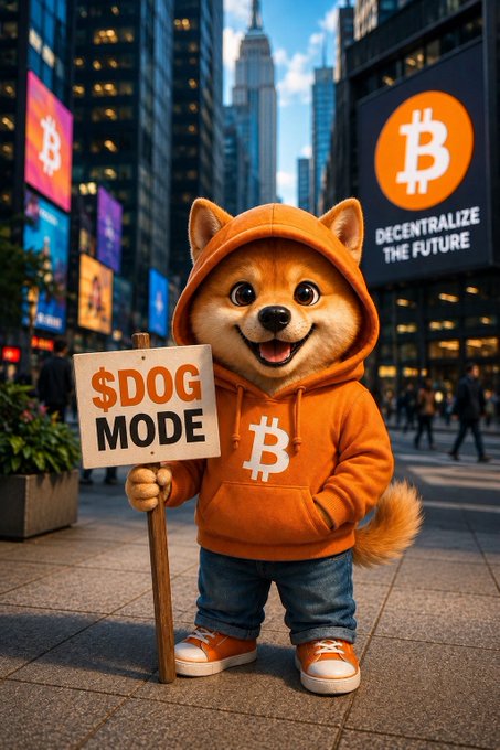 An illustration of a Shiba Inu dog wearing an orange hoodie with a Bitcoin logo, holding a '$DOG MODE' sign in a city street with a Bitcoin billboard reading 'DECENTRALIZE THE FUTURE.'