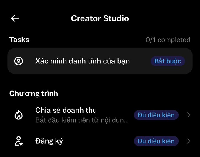 A screenshot of the Creator Studio app interface showing Tasks (0/1 completed) with a required identity verification, and programs including "Chia sẻ doanh thu" (Revenue sharing) and "Đăng ký" (Subscribe) both marked as eligible ("Đủ điều kiện"). The image illustrates the post's warning about waiting and building consistently, as the creator has met the eligibility requirements for monetization programs.