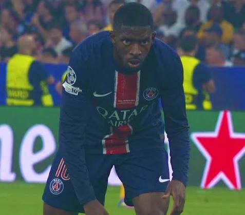 A photo of footballer Ousmane Dembélé wearing a Paris Saint-Germain jersey with the Qatar Airways sponsor logo, bent over on the pitch.