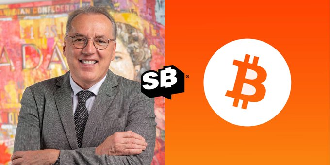 A promotional image featuring a smiling man in a grey suit on the left, an "SB" logo in the middle, and the Bitcoin (₿) logo on an orange background on the right.